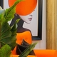 LADY IN ORANGE DISK HAT FRAMED ART